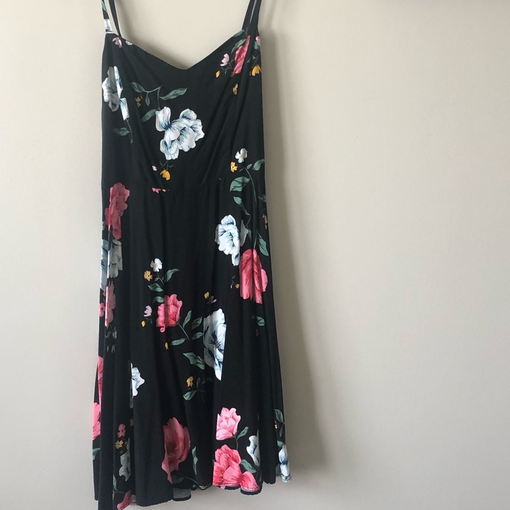 Black dress with colorful flowers, fit at the waist and flowy.